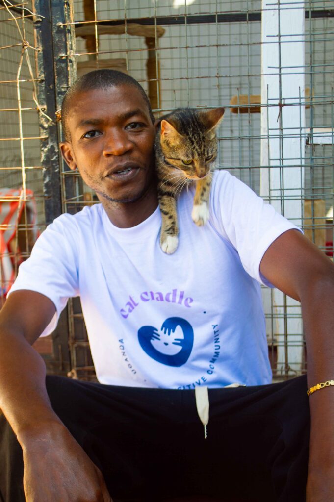 Liam Dyogo with the cats at Cat Cradle Uganda